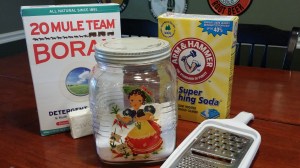 My laundry soap jar pictured with all the ingredients (and my grater.)